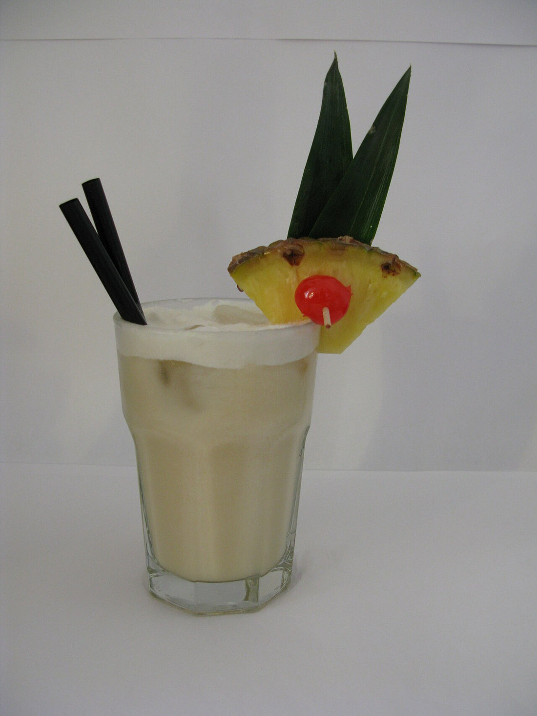 Piña Colada cocktail with pineapple and cherry garnish